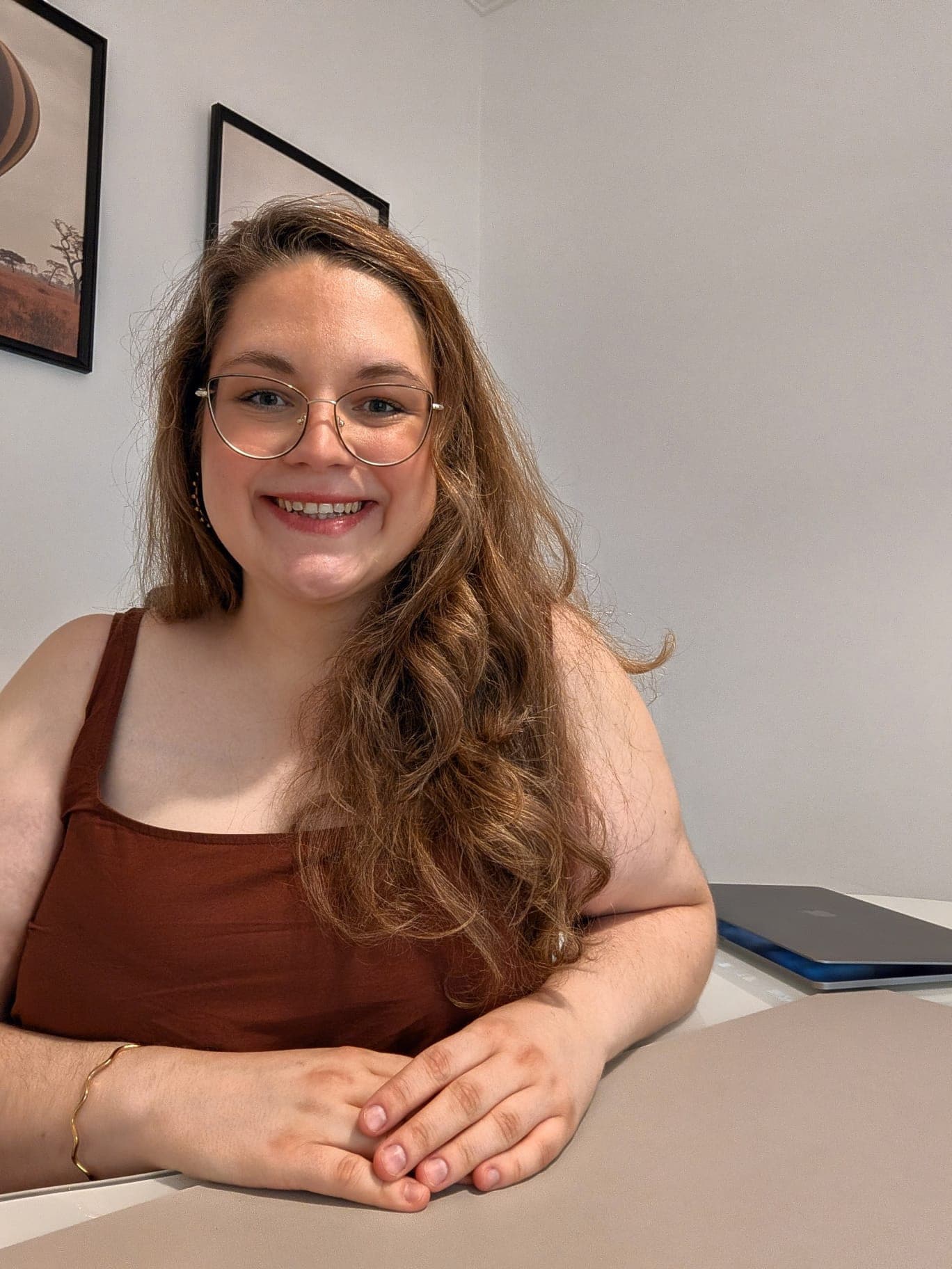 Inés Fuhrer sonriendo, sentada en su mesa de trabajo